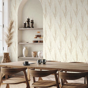 Dining Room - A modern area with a wooden table, chairs, built-in shelves holding ceramic vases and candles, and a vase of dried pampas grass by a bright window is accented by York Wallcoverings’ Graceful Willow Cotton Wallpaper (60 SqFt)