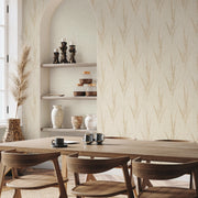 Dining Room - A area with wooden chairs and table, simple tableware, and shelves displaying vases and candles. Decor in earthy tones features York Wallcoverings’ Graceful Willow Pale Straw Wallpaper (60 SqFt) with a subtle vertical leaf pattern