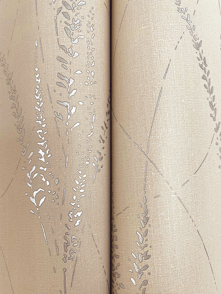 Graceful Willow Putty Wallpaper by York Wallcoverings features beige tones with a subtle texture and delicate metallic silver leaf and branch pattern. A vertical seam runs down the center, slightly interrupting the design’s flow. Covers 60 sq ft.