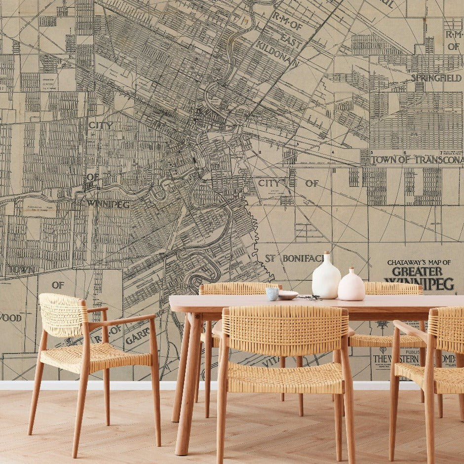 A stylish dining area with modern furniture and a wooden table, set against a large Decor2Go Wallpaper Mural depicting a vintage map of greater Winnipeg.