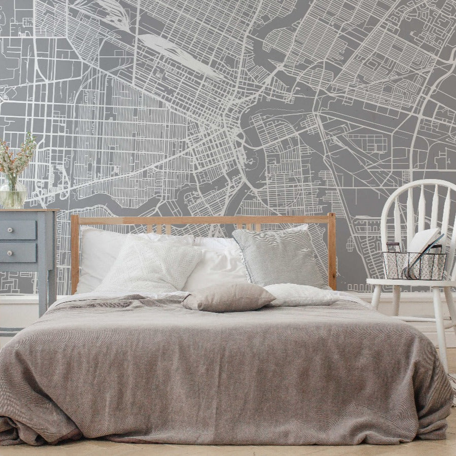 Bedroom - A modern bedroom with a grey Decor2Go Wallpaper Mural Winnipeg Wallpaper Mural, white rocking chair, and blue nightstand, against a wall featuring an architectural wall design of Winnipeg.