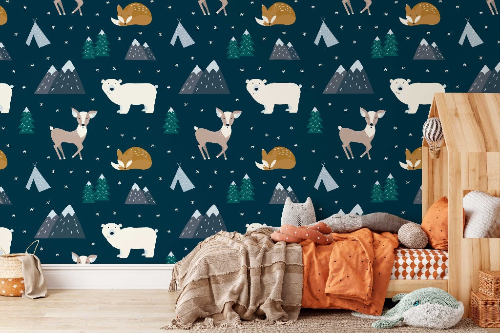 A cozy children's room corner with a bed covered in orange and brown blankets, surrounded by stuffed toys, next to a wall with a Decor2Go Wallpaper Mural Hand Drawn Animal Forest Wallpaper Mural.