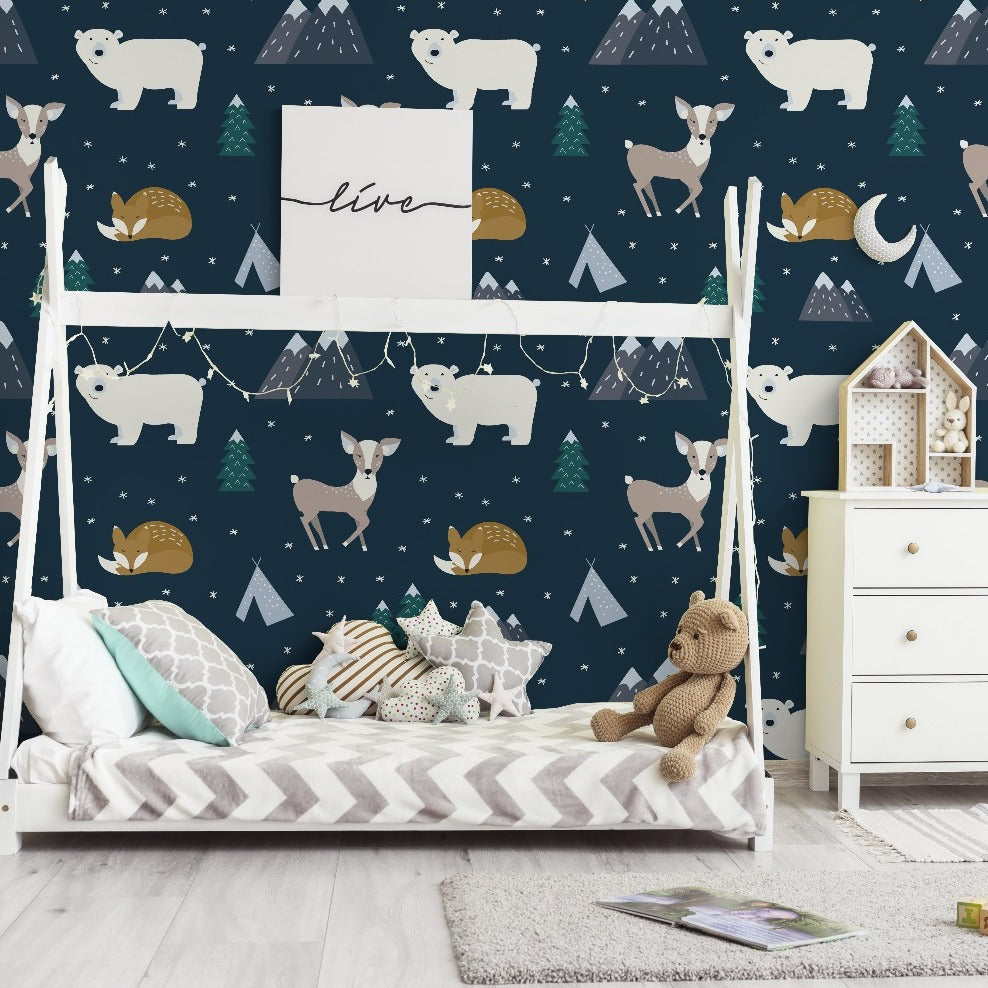 A child's bedroom with a Decor2Go Wallpaper Mural featuring a hand-drawn animal forest wallpaper, along with a small bed with a teddy bear, a white dresser, and a house-shaped shelf.