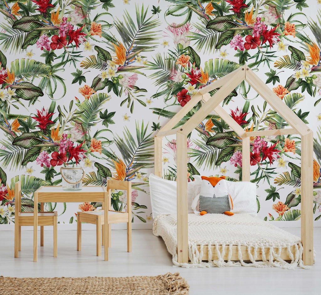 A bright, tropical-themed bedroom featuring a wooden house-shaped frame bed with white bedding, a wooden side table with a glass of water, and vibrant Decor2Go Wallpaper Mural with lush greenery.