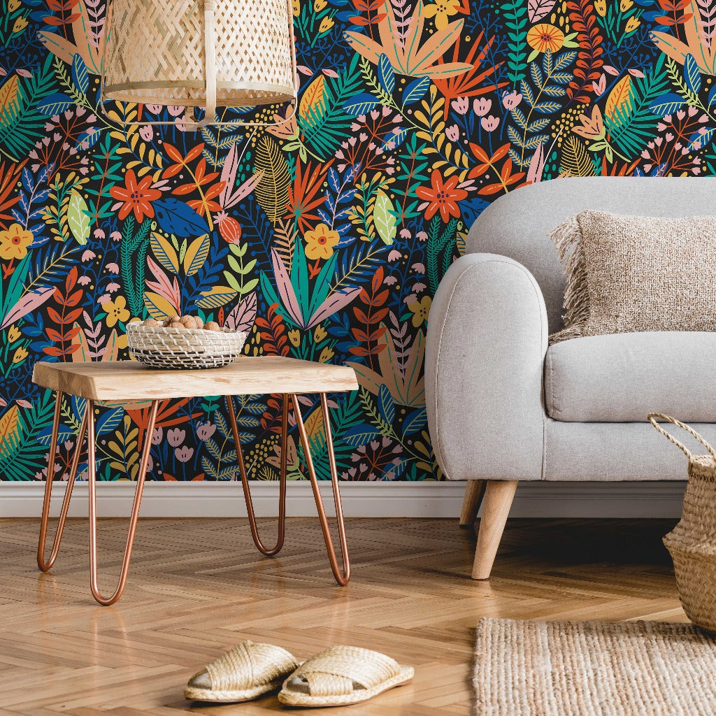 A cozy living room corner with a gray sofa, a wooden side table with copper legs, and a Heart of the Jungle Wallpaper Mural by Decor2Go Wallpaper Mural. A pair of slippers rests on the wooden floor beside a woven basket.