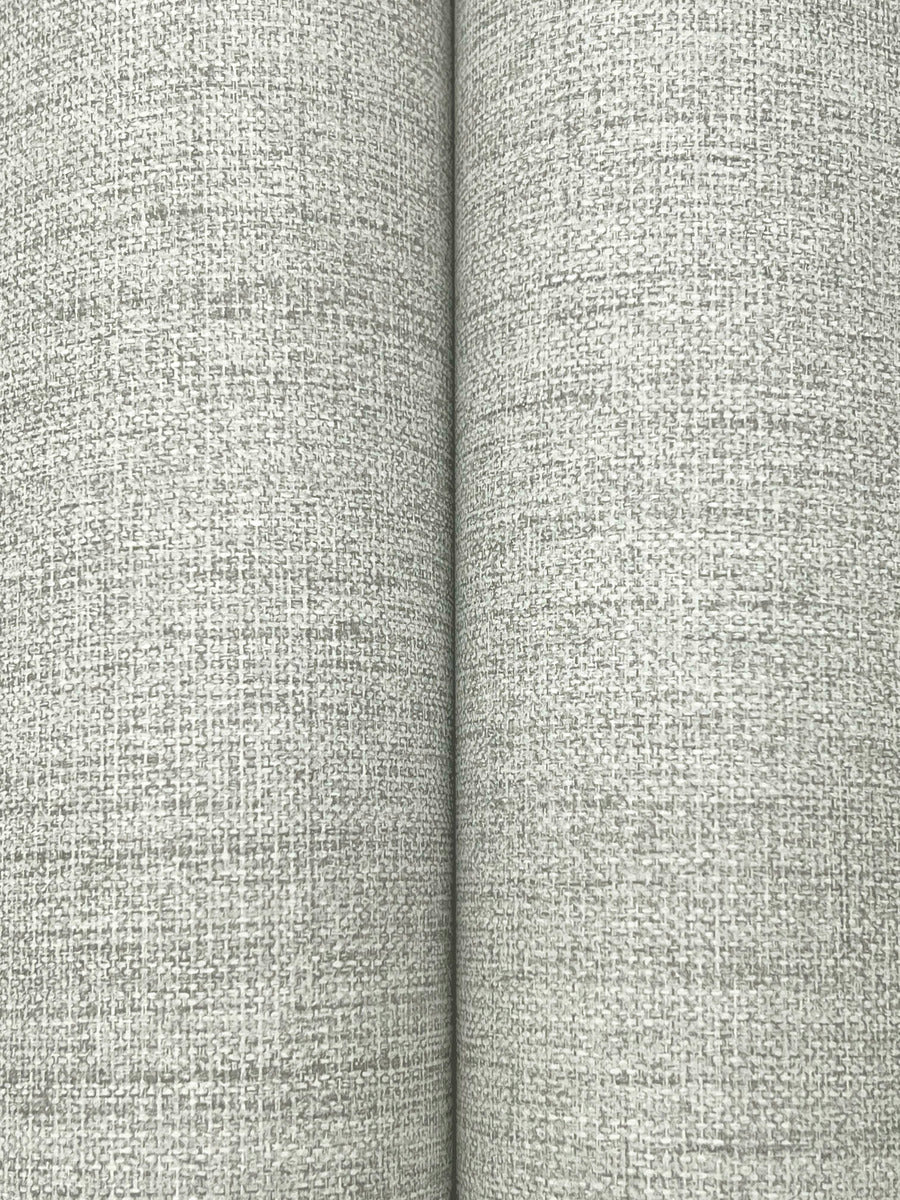 A close-up of two pages resembles the textured, light gray surface of York Wallcoverings' Hillswick Tweed Pewter Wallpaper (60 SqFt), featuring a faint rectangular pattern and a visible vertical seam at the page center.