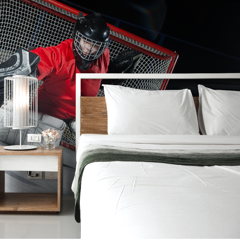 A split image combining two contrasting scenes: on the top, a Decor2Go Hockey Goalie Wallpaper Mural features a goalie in red gear crouching by the goal, while the bottom shows a serene bedroom.
