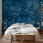 Bedroom - A cozy bedroom featuring a large bed with grey bedding, set against an eye-catching Decor2Go Wallpaper Mural. A wooden bedside table, shelf, and a bench with an open book add warmth to the scene.