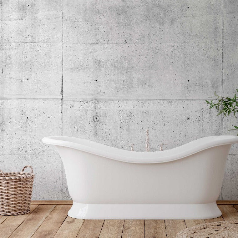 A modern white bathtub stands against a Decor2Go Wallpaper Mural, accompanied by a wicker basket and a large clay pot with a green plant, on a woven mat.