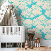 Nursery - A stylish nursery featuring a white crib, a tepee canopy, a Decor2Go Living in the Clouds Wallpaper Mural, a knit blanket on a chair, and wooden stools on a circular rug.