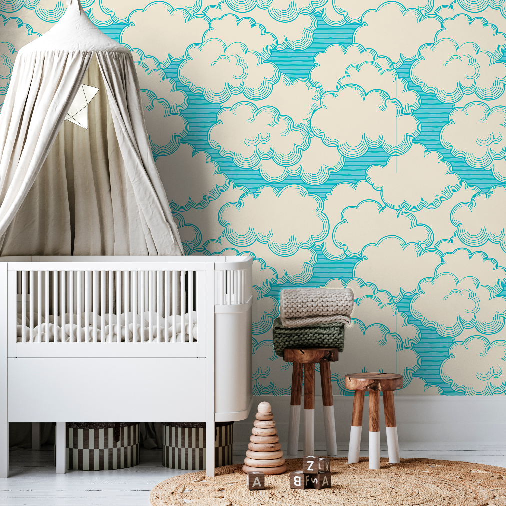 A stylish nursery featuring a white crib, a tepee canopy, a Decor2Go Living in the Clouds Wallpaper Mural, a knit blanket on a chair, and wooden stools on a circular rug.