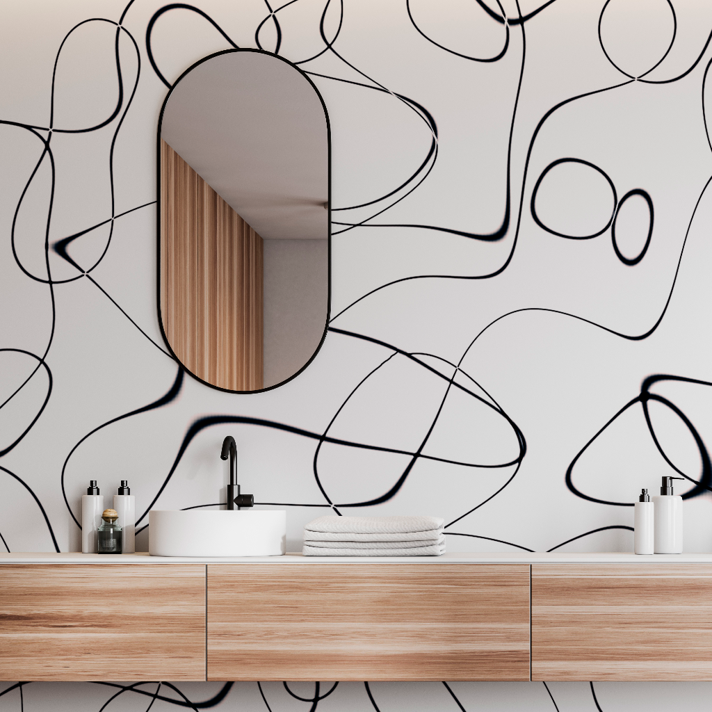 A modern bathroom with a wooden vanity and an oval mirror. The wall behind features a unique Lovely Swirls Wallpaper Mural by Decor2Go Wallpaper Mural's black and white artistic design.