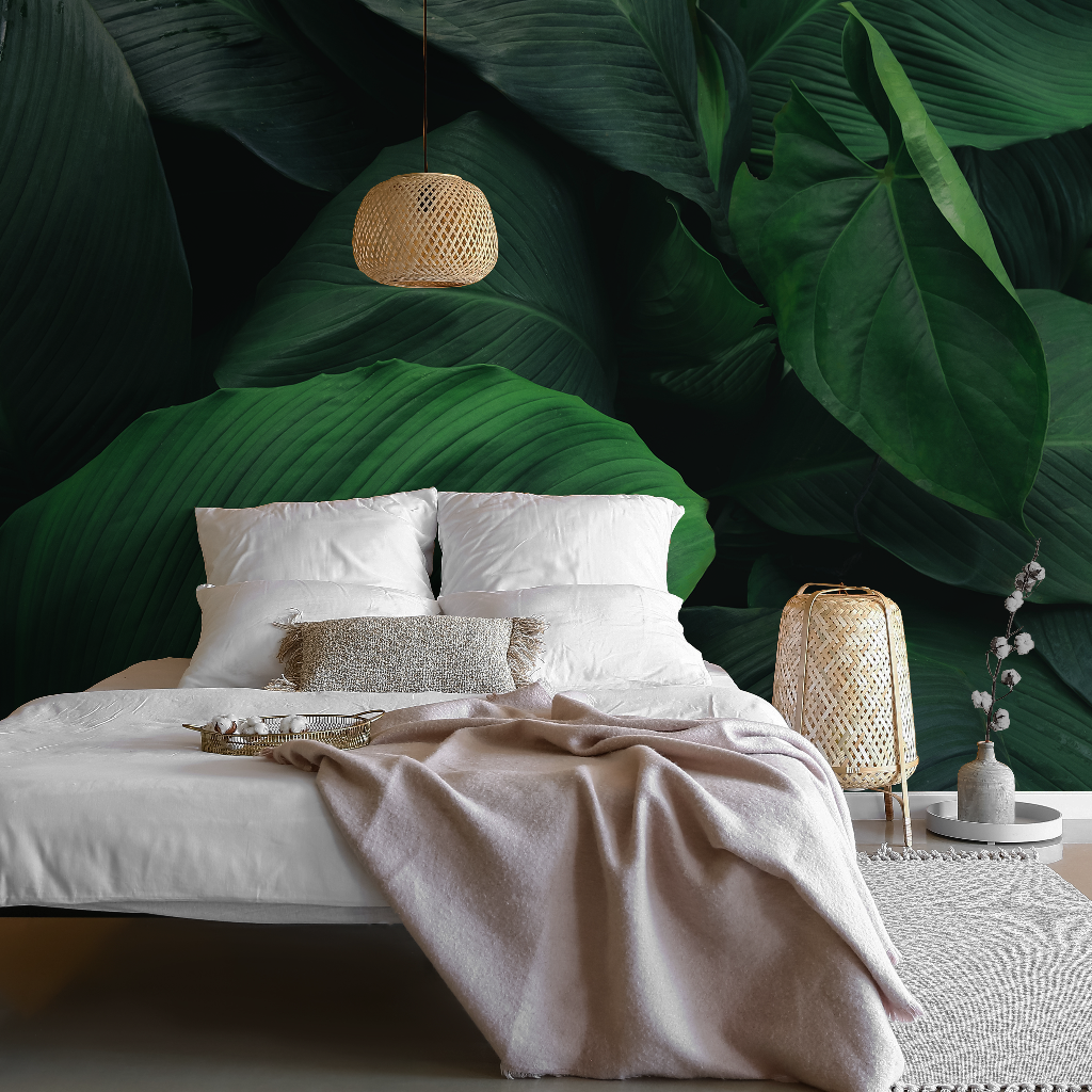 A stylish bedroom featuring a large bed with white and gray bedding against a vibrant Decor2Go Wallpaper Mural. A rattan pendant light and bedside lantern add to the serene, natural ambiance.