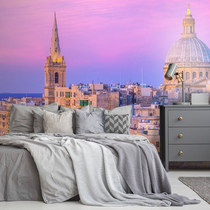 Modern bedroom with a large bed and gray bedding in front of a floor-to-ceiling window showcasing a captivating view of Decor2Go Wallpaper Mural over a city with historic dome-topped buildings.