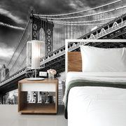 Bedroom - A bedroom with a large bed and a wooden nightstand featuring a lamp and flowers, with a dramatic Decor2Go Wallpaper Mural of the Manhattan Bridge on the wall behind it.