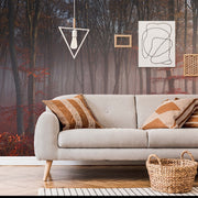 Living Room - A modern living room with a gray sofa adorned with patterned cushions, a wicker basket, and abstract wall art, overlooking a Decor2Go Wallpaper Mural featuring the Misty Red Forest Wallpaper Mural.