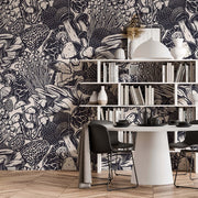 A stylish dining area featuring a modern round white table with two black chairs, against an intricate Decor2Go Wallpaper Mural, and white shelving decorated with various vases.