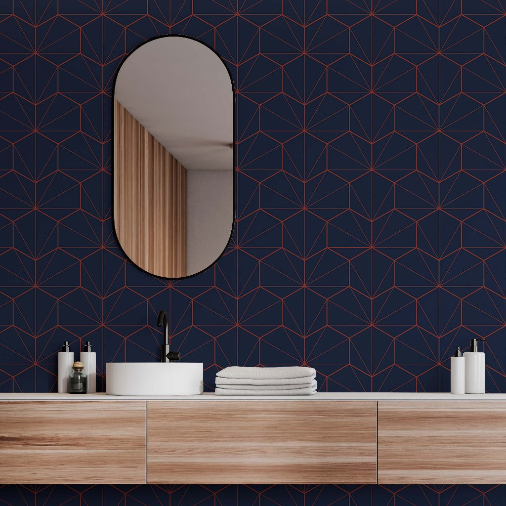 A modern bathroom interior featuring a wooden vanity with folded white towels, skin care products, and an oval mirror on a Navy and Red Hexagons Wallpaper Mural by Decor2Go Wallpaper Mural.