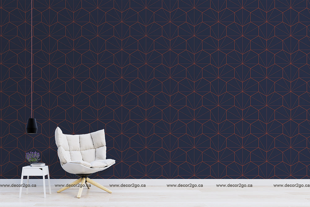 A minimalistic living room with a Navy and Red Hexagons Wallpaper Mural from Decor2Go Wallpaper Mural, featuring a single modern white armchair, a small table with a book and plant, and a hanging black lamp.