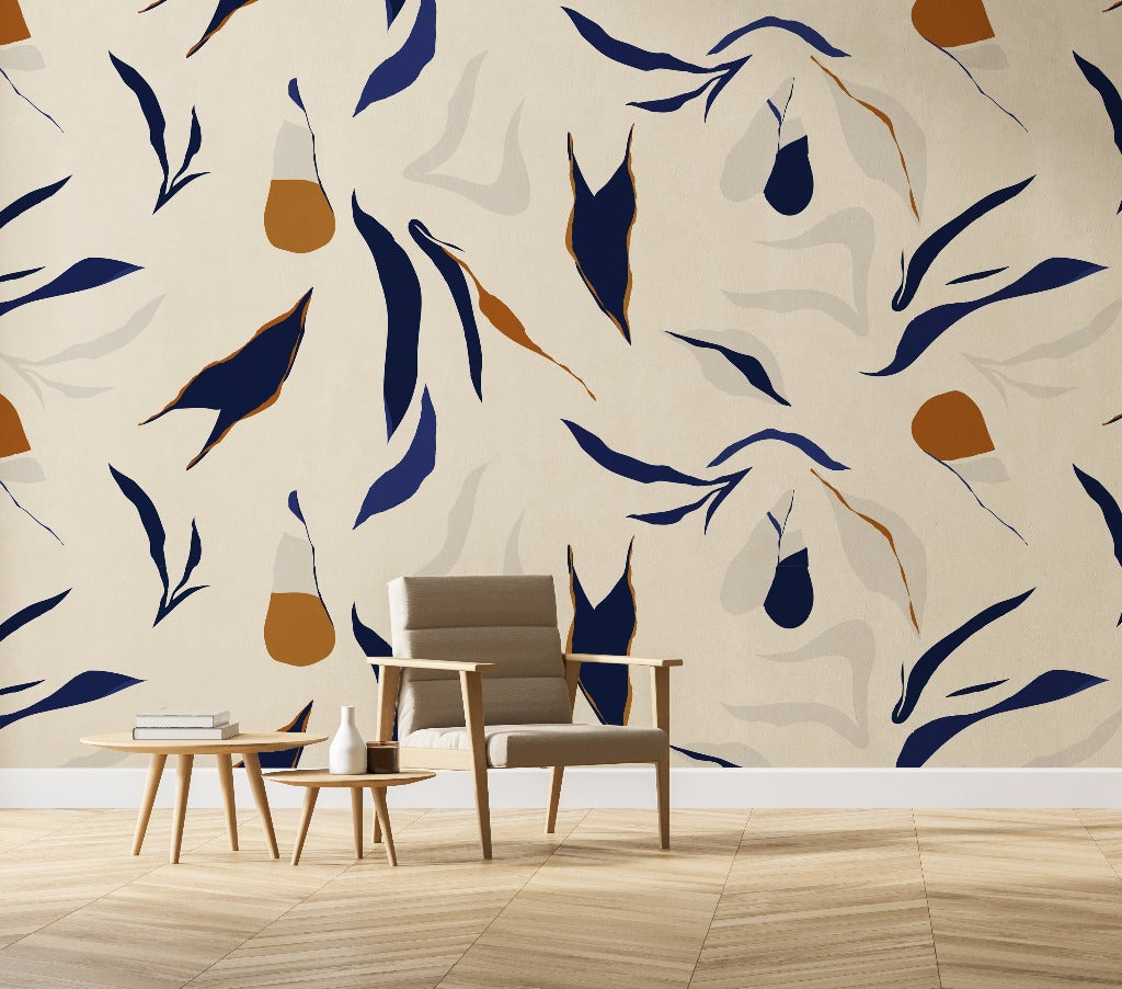 A modern living room corner with a stylish armchair and a small round table against a feature wall featuring a large, Decor2Go Wallpaper Mural in blue, beige, and orange tones.