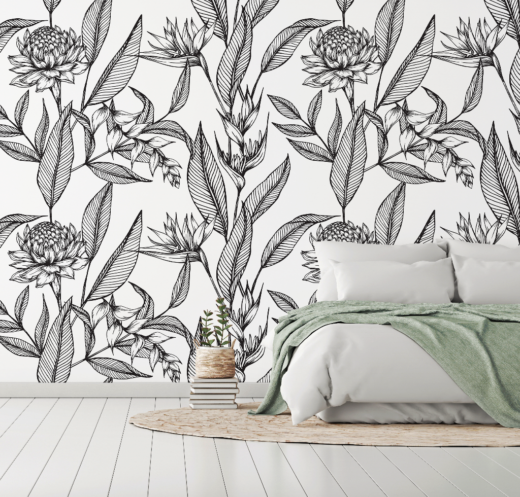Bedroom - A modern bedroom with a white wall decorated with an artistic Decor2Go Paradise Flower Wallpaper Mural design, featuring a double bed with white bedding and a green throw, and a small wooden stool with books and a plant.