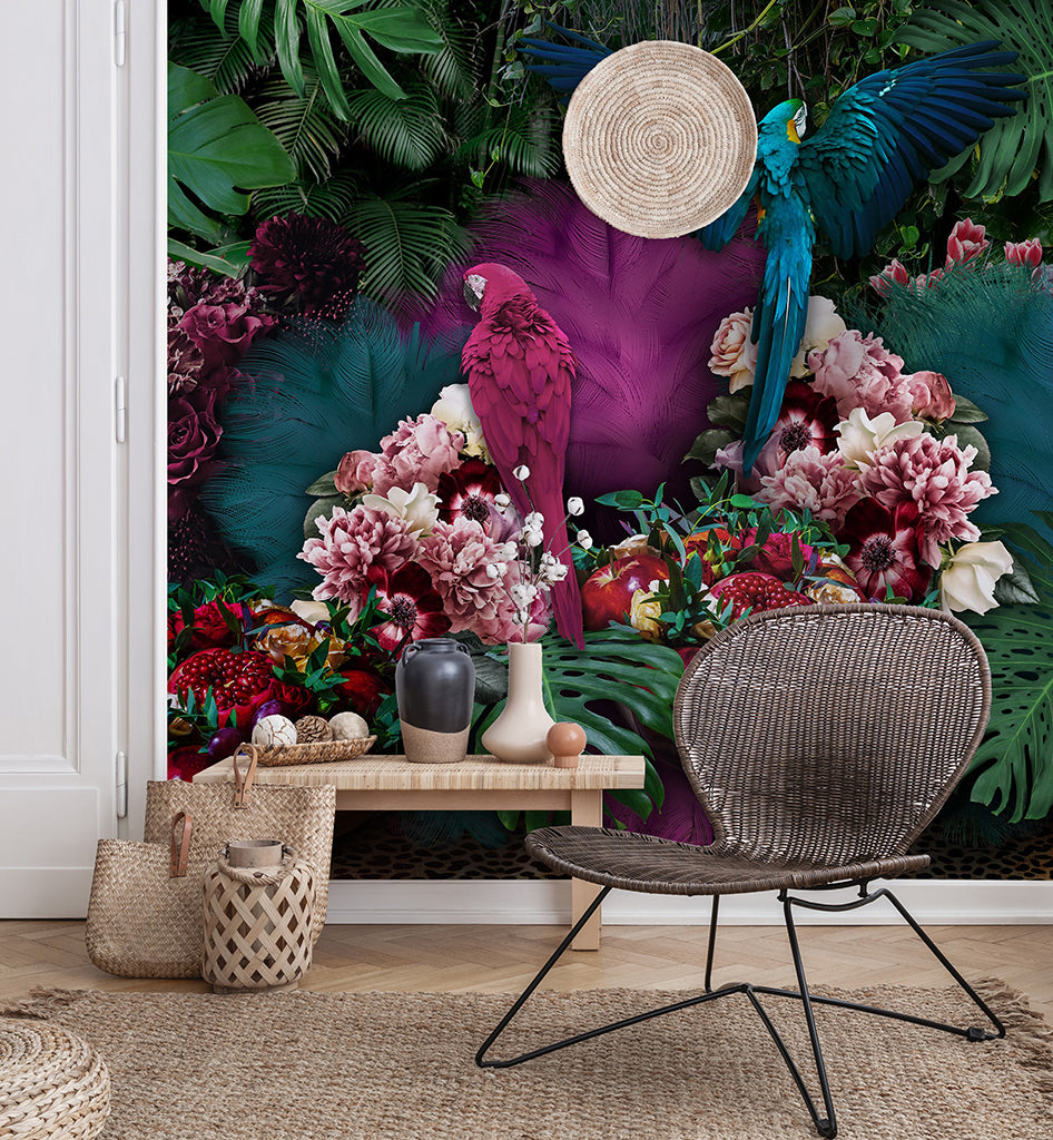 Vibrant tropical-themed living room with a detailed Parrot Paradise Wallpaper Mural from Decor2Go, a wicker chair, wooden bench, and decorative items like a straw hat and pottery.