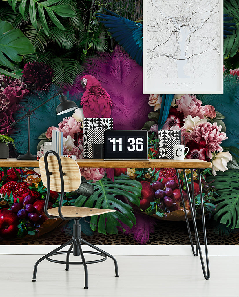 A vibrant home office setup with a desk adorned with colorful flowers and fruits, an industrial-style chair, a Parrot Paradise Wallpaper Mural from Decor2Go Wallpaper Mural, and a wall clock reading 11:36 complement the scene.