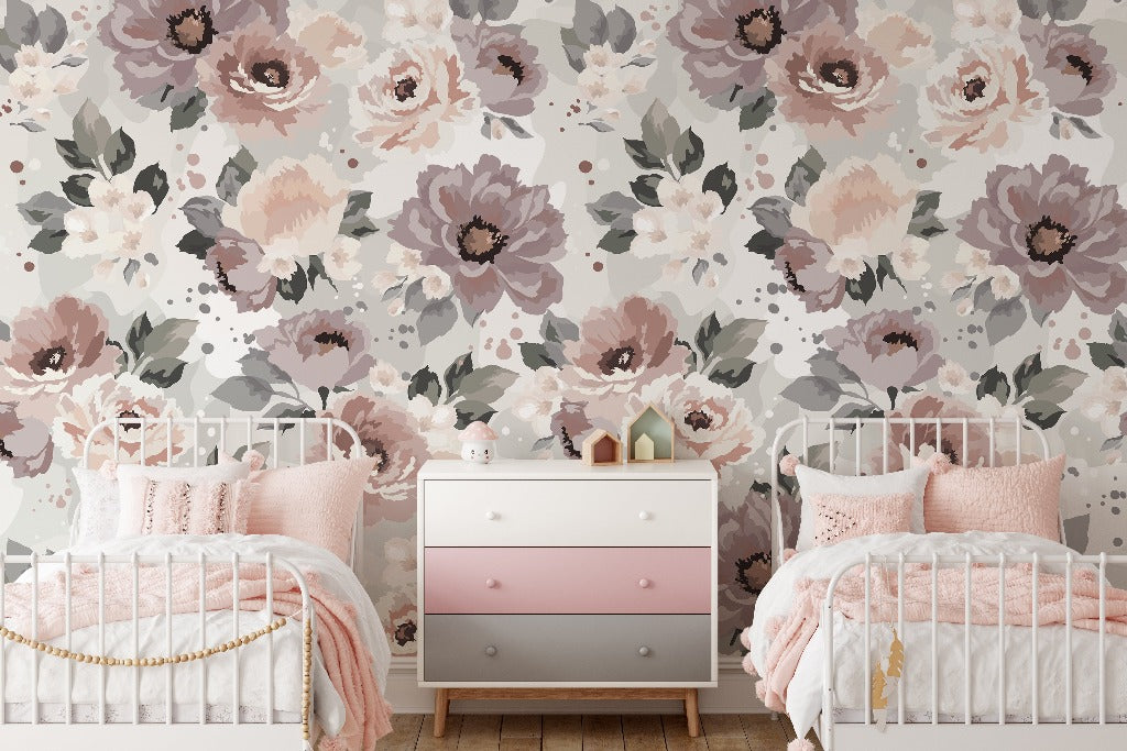 A cozy children's bedroom with two white vintage metal beds, pink bedding, and a pink and white dresser. The room features a Decor2Go Wallpaper Mural in shades of pink and gray.