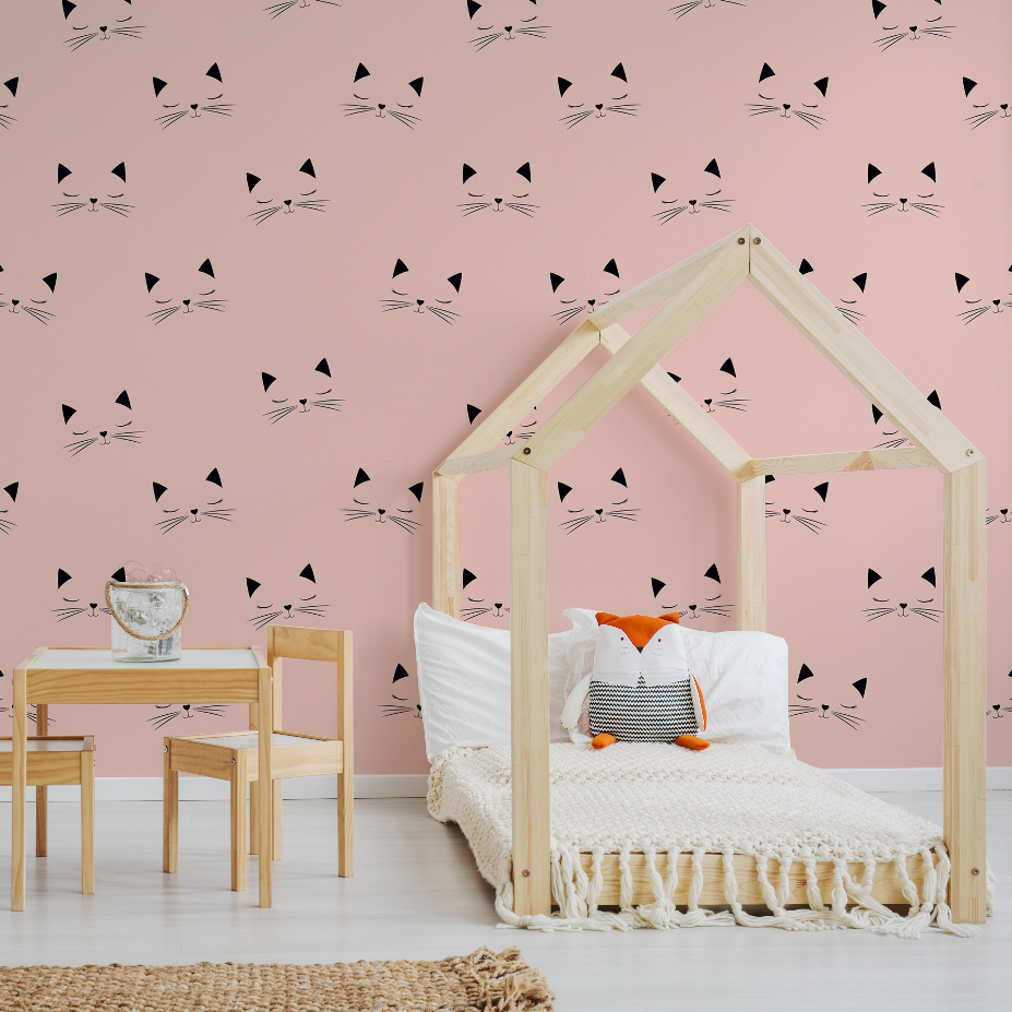 Bedroom - A cozy children's bedroom featuring a wooden house-framed bed with white bedding, wood table and chairs, and a pink wall adorned with a Decor2Go Wallpaper Mural.