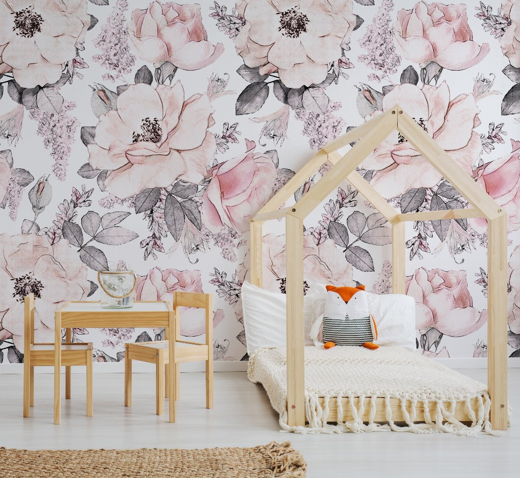A cozy children's bedroom featuring a wooden house-shaped bed frame with a white knit blanket, a small wooden table and chairs, and a Decor2Go Wallpaper Mural.