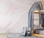 A cozy children's bedroom featuring a wooden canopy bed draped with twinkling fairy lights and a soft gray blanket. The room has a whimsical Decor2Go Wallpaper Mural and a plush gray rug on the floor.