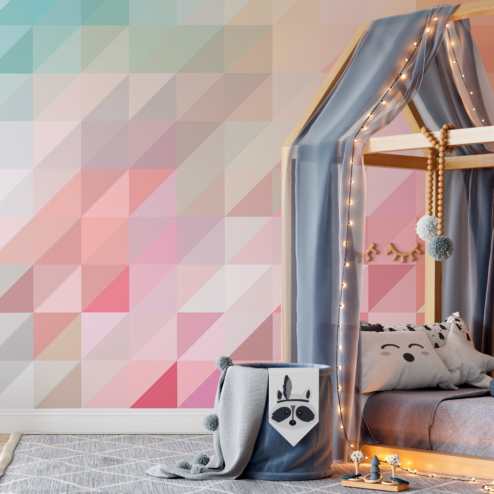 A cozy children's room featuring a wooden canopy bed draped with sheer curtains and string lights. The bed is adorned with plush pillows and a blanket, next to a Decor2Go Wallpaper Mural Pink and Blue Geometry Wallpaper Mural.