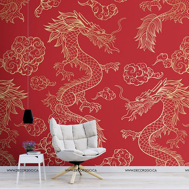 An elegant room with vibrant Decor2Go Wallpaper Mural Red Dragon wallpaper featuring golden dragon and cloud motifs. A stylish white chair and a small side table with books and a plant are near the left wall.