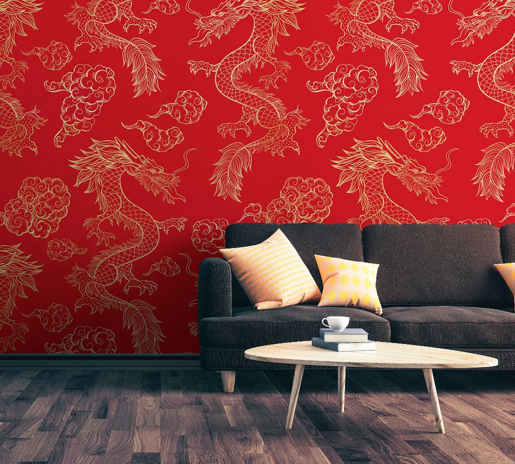 A stylish living room featuring a dark gray couch with colorful pillows, a small round white coffee table, and vibrant Decor2Go Wallpaper Mural adorned with golden dragon designs. The floor is a dark wood finish.