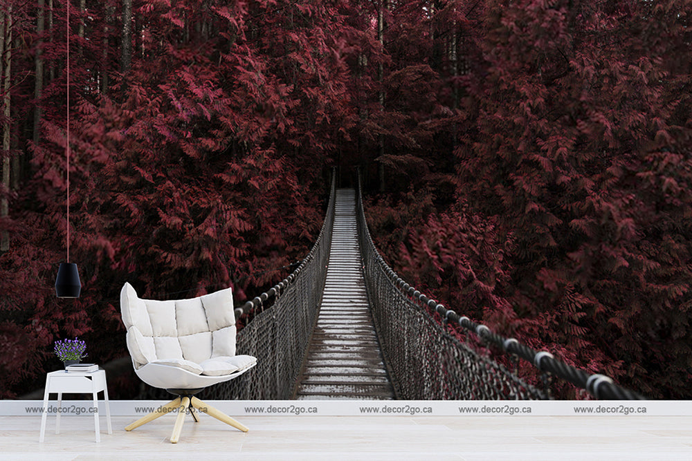 A serene digital composite image featuring a Decor2Go Wallpaper Mural Red Forest Wallpaper Mural in a room that opens to a surreal view of a suspension bridge leading into a dense forest with vibrant crimson touch.
