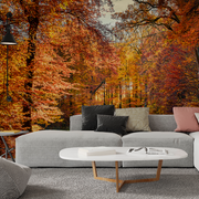 Living Room - A cozy modern living room with a gray sofa and a round white coffee table, facing a vibrant autumn mural scene with orange and yellow foliage printed on the Decor2Go Wallpaper Mural Riding Red Wallpaper Mural accent wall.