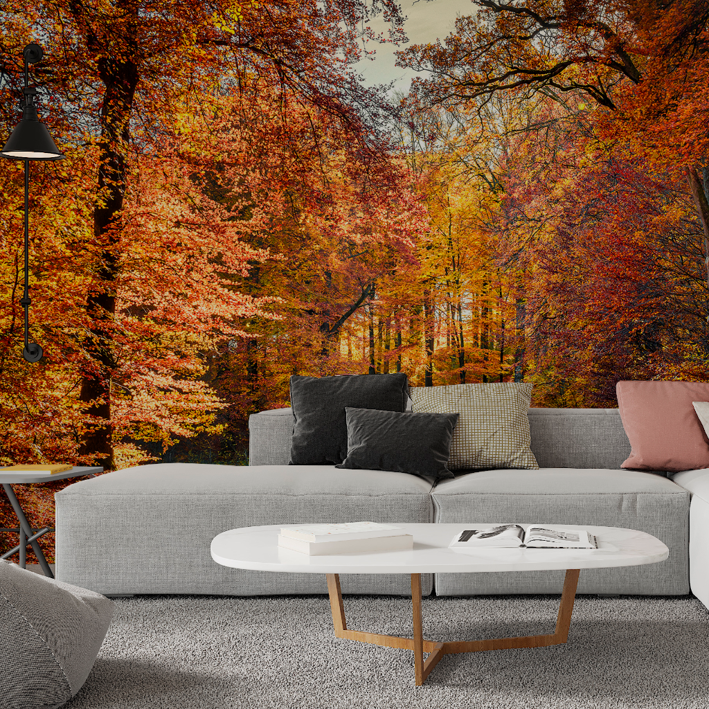 A cozy modern living room with a gray sofa and a round white coffee table, facing a vibrant autumn mural scene with orange and yellow foliage printed on the Decor2Go Wallpaper Mural Riding Red Wallpaper Mural accent wall.