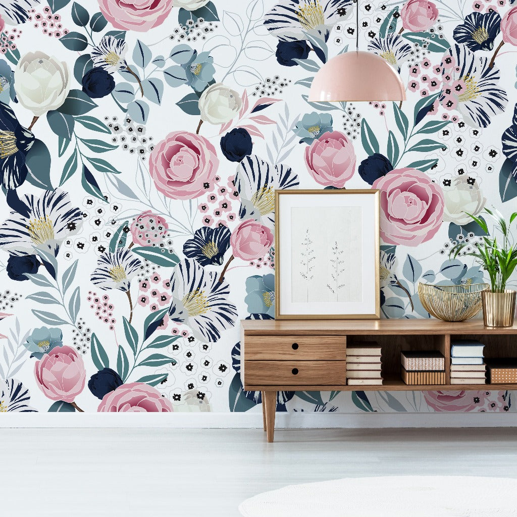 A stylish interior featuring an Imaginative design Air Balloon Whale Wallpaper Mural with large blue and pink blooms, a wooden sideboard with plants, books, and a framed artwork, under a pink pendant light.