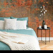 Bedroom - A cozy bedroom corner with a teal bedspread, white knit throw, and pillows against a Decor2Go Wallpaper Mural. A side table holds decorative vases and flowers next to an open book.