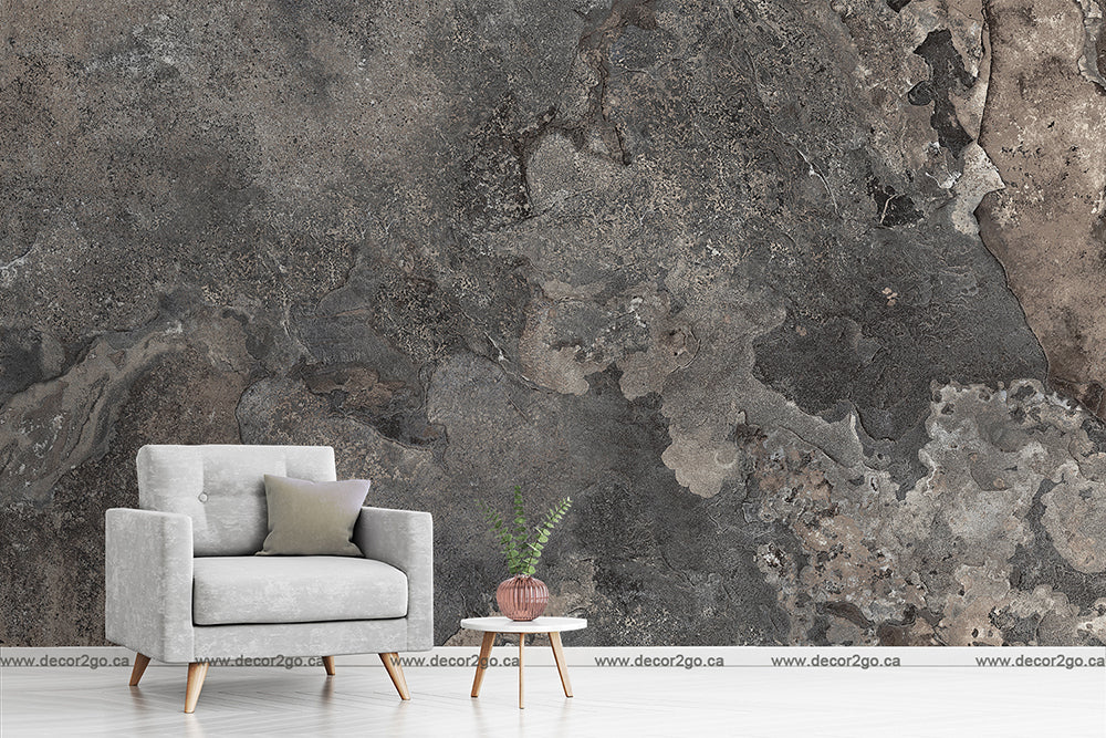 Modern minimalist living room featuring a gray armchair with cushions, a small wooden side table with a Decor2Go Wallpaper Mural, set against a textured gray and brown stone wall.