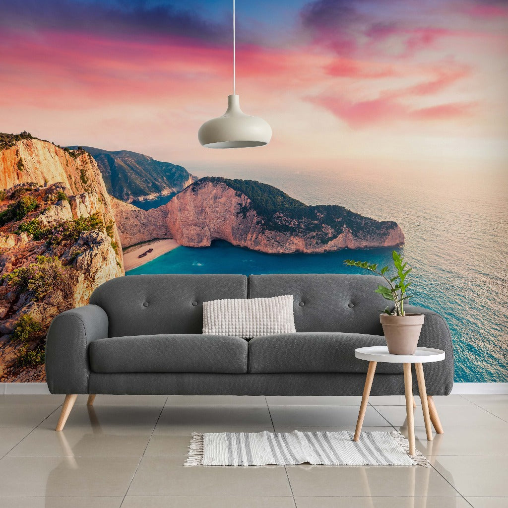 Living Room - A modern living room with a gray sofa, white rug, and small wooden table, set against a large floor-to-ceiling feature wall of a dramatic Sea Horizon Wallpaper Mural by Decor2Go Wallpaper Mural at sunset.