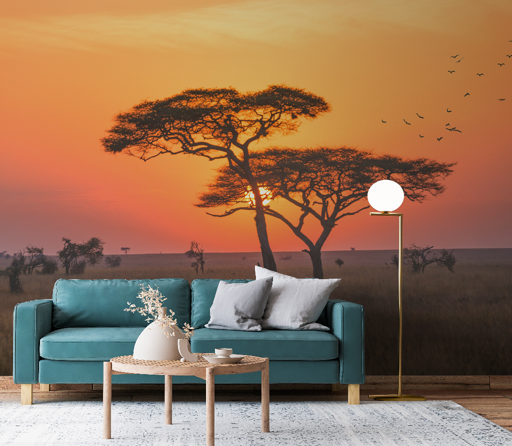 Living Room - A contemporary living room with a teal sofa, wooden coffee table, and a floor lamp, set against a large wall mural of an African savannah scene at sunset, featuring an acacia tree and flying
Decor2Go Wallpaper Mural's Serengeti Sunrise Wallpaper Mural.