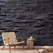 A cozy nook with a beige armchair and a small wooden side table holding a white cup, against Decor2Go Wallpaper Mural. An open book lies on the floor nearby.