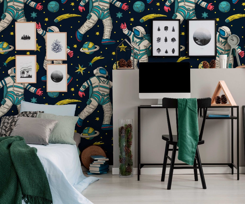 Bedroom - A vibrant bedroom-office with Decor2Go Wallpaper Mural featuring astronauts and planets. A desk with a computer, a cozy bed with green blankets, and framed artwork on the wall.
