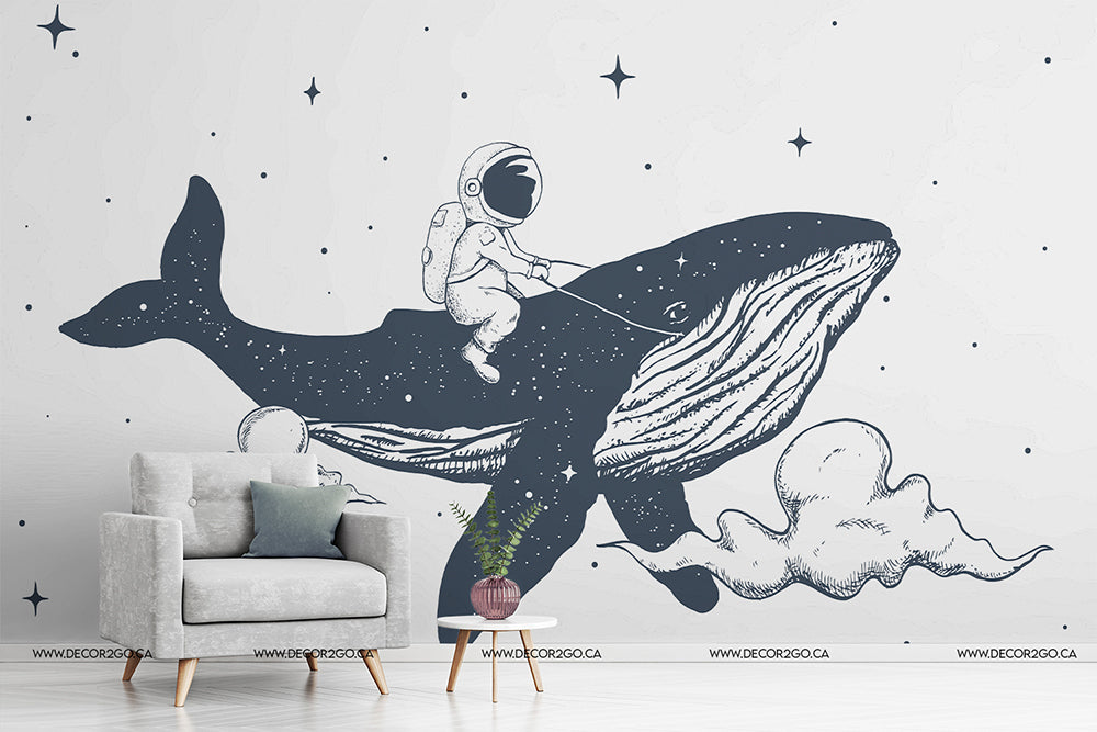 Living Room - Illustrative Space Whale Wallpaper Mural depicting an astronaut riding a space whale through a star-filled sky, set in a modern living room with a grey armchair and small plant by Decor2Go Wallpaper Mural.