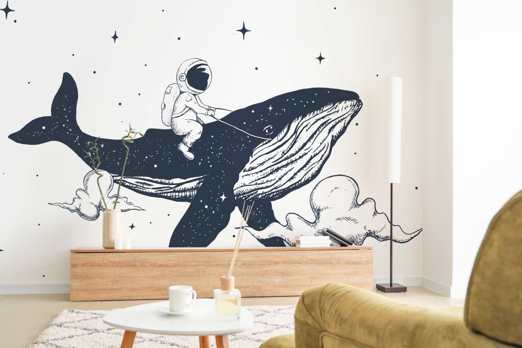 A whimsical wall mural depicting an astronaut riding a Decor2Go Wallpaper Mural against a starry backdrop in a cozy room with modern furniture.