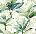 An illustration of tropical foliage featuring large, overlapping leaves in various shades of green and blue, set against a light background. This Summerhouse Savanna Wallpaper Blue, Beige (60 Sq.Ft.) by York Wallcoverings exudes a lush and lively feel with detailed leaf patterns adding depth and texture, perfect as removable wallpaper for easy installation.