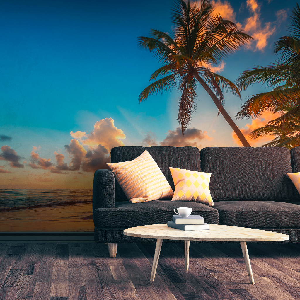 A contemporary living room setup with a dark sofa and a white oval coffee table, set against a vibrant Decor2Go Wallpaper Mural with palm trees.
