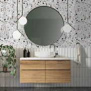 Bathroom - A modern bathroom featuring a round mirror hanging above a wooden vanity with a white basin. The wall is adorned with Decor2Go Wallpaper Mural in luxurious terrazzo design. There are hanging spherical lamps and a potted plant to the left.