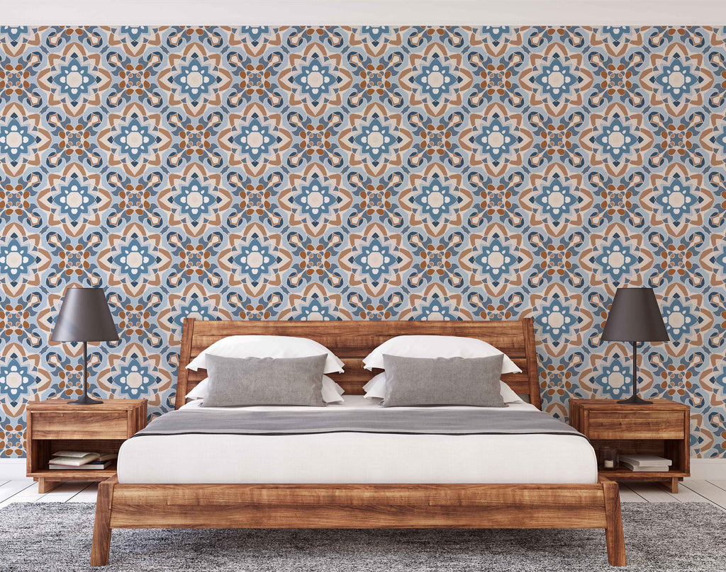 A modern bedroom featuring a wooden bed with white bedding and two pillows, flanked by wooden nightstands with gray lamps. The room has a vibrant blue and brown Decor2Go Wallpaper Mural Moroccan-style wallpaper.